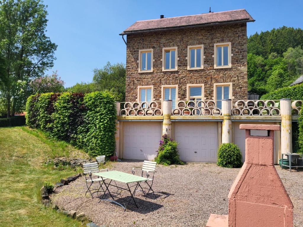 une maison avec une table et des chaises devant elle dans l'établissement Die Alte Schule app, à Saint-Vith