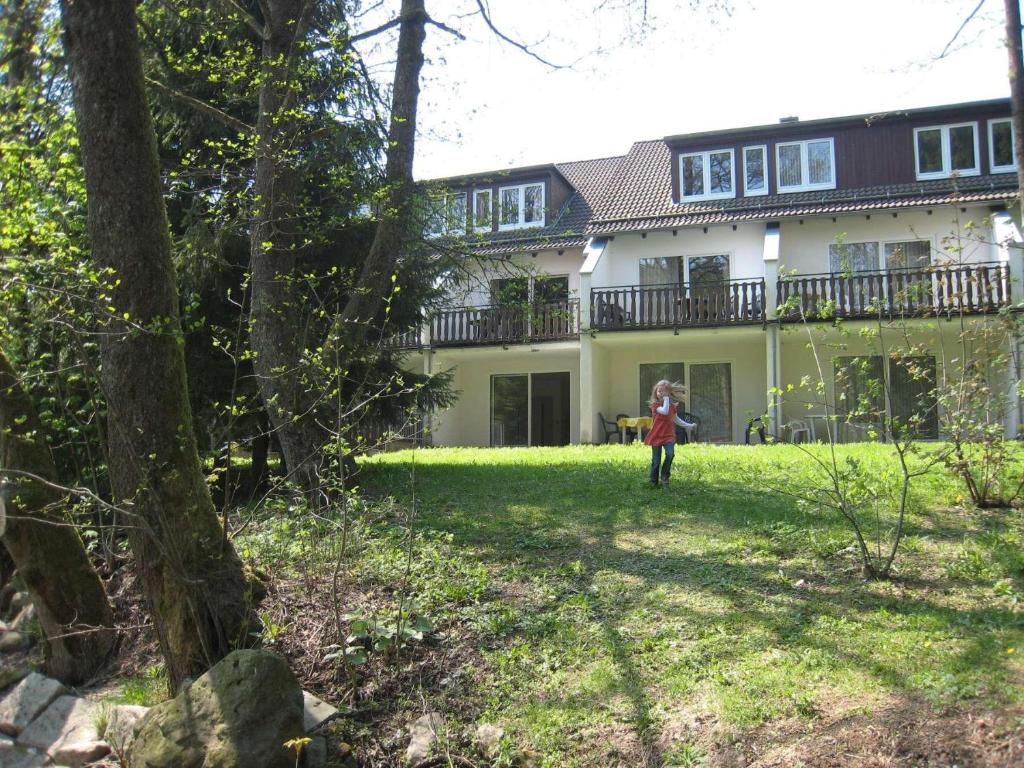 a girl standing in the yard of a house at Ferienwohnung-Am-Wurmberg-1 in Braunlage