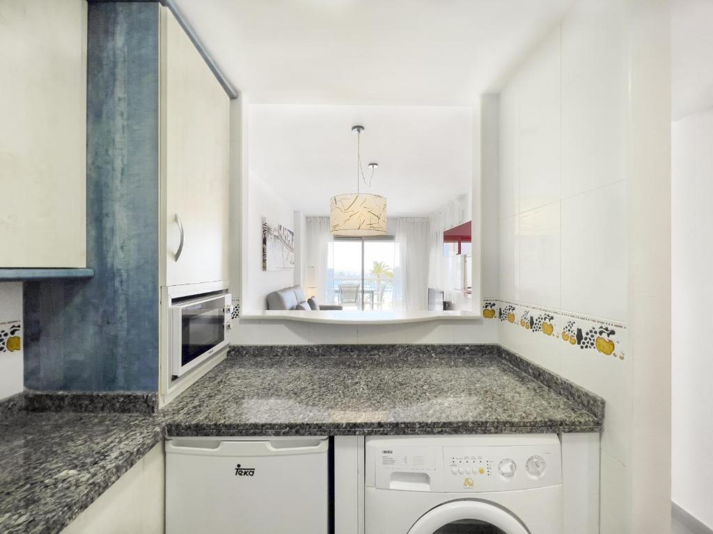 a kitchen with a washing machine and a sink at Apartamentos Hipocampos Calpe Rent Apart in Calpe