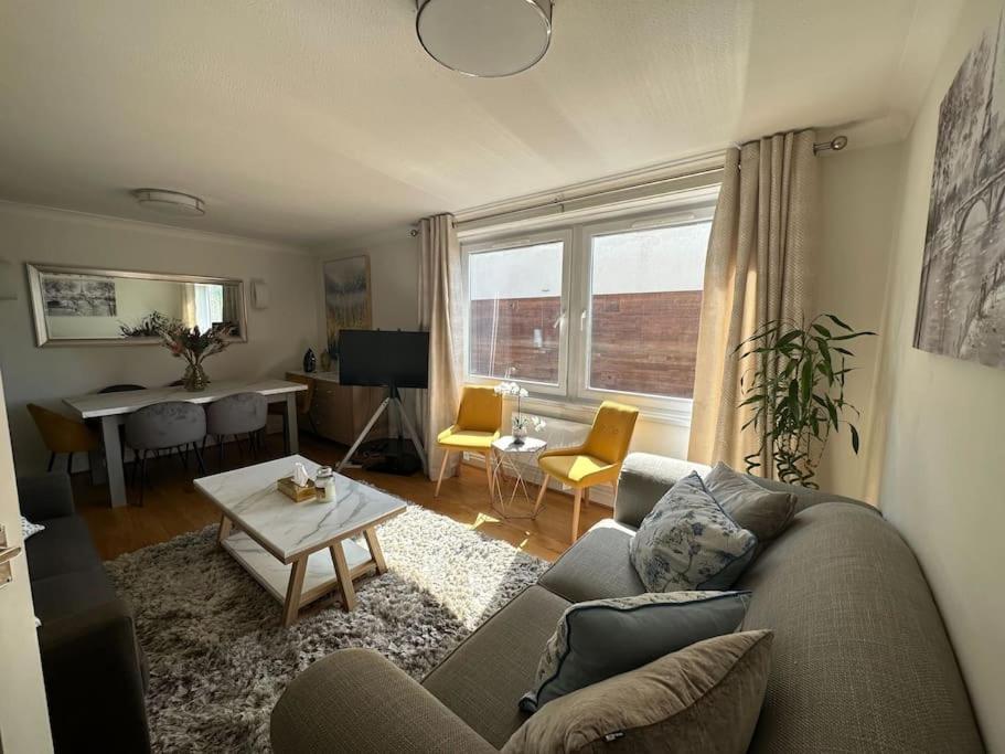 a living room with a couch and a table at Chic 3 Bed in the heart of Chiswick in London