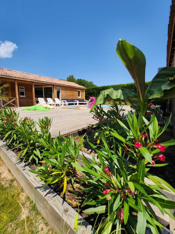 a house with a wooden deck and some plants at Le clos de lignac in Cieux