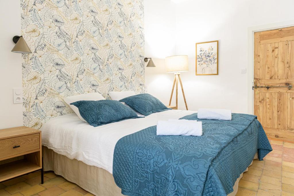 um quarto com uma cama com lençóis azuis e brancos em La Tour Des Remparts em Rochemaure