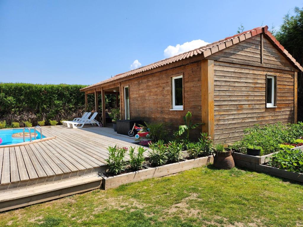 a tiny house with a deck and a backyard at Le clos de lignac in Cieux