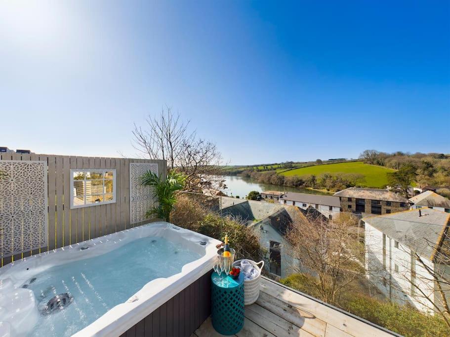 a hot tub on a balcony with a view of a river at Paddlers View - Luxurious 2 bed, hot tub. Town centre, water views in Kingsbridge