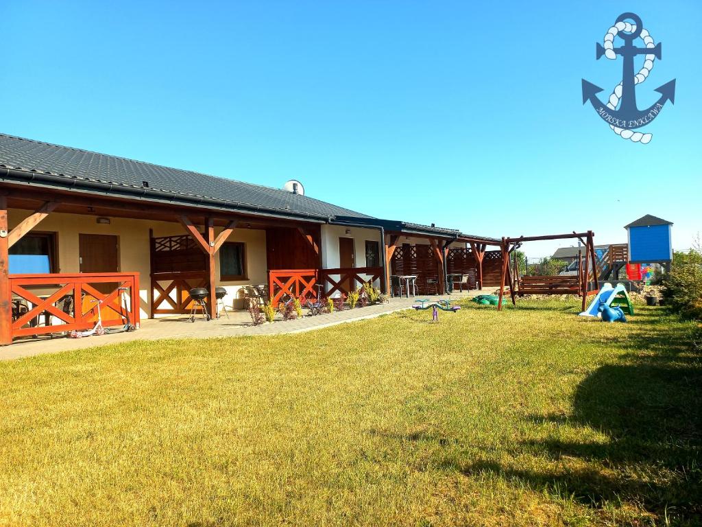 a building with a playground in front of a yard at Morska Enklawa in Gąski