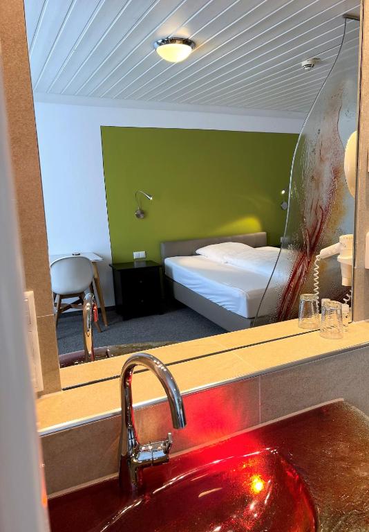 a bathroom with a sink and a bedroom with a bed at Altötting City Apartments in Altötting