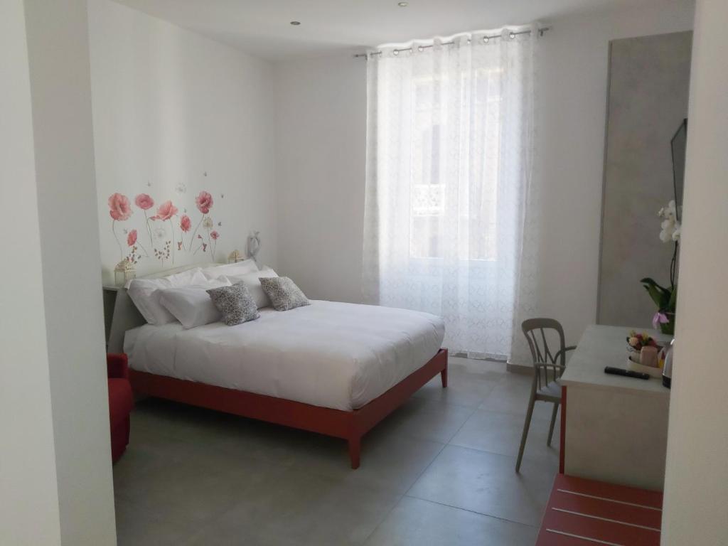 ラ・スペツィアにあるCandy's dream roomsのベッドと窓のある白い寝室