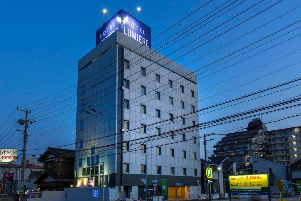 a building with a blue sign on top of it at ホテルルミエール in Narashino