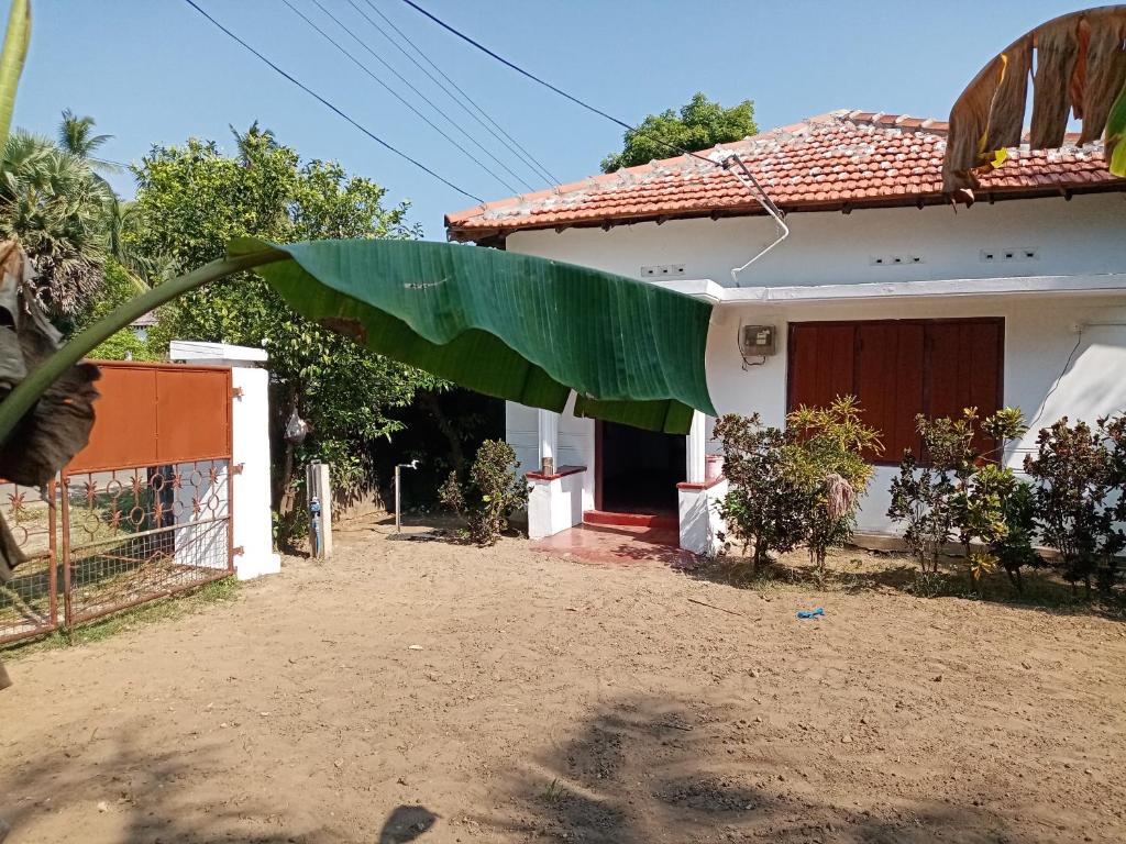 una casa con una grande foglia verde davanti di Rest house nilaveli a Trincomalee