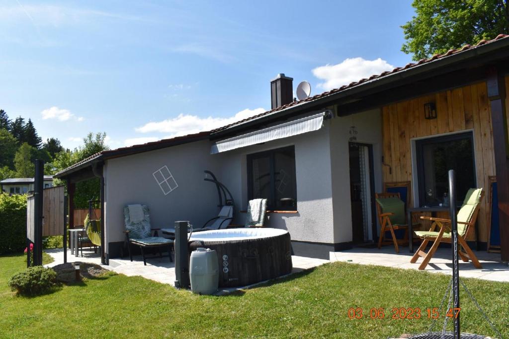 una pequeña casa con un patio trasero con una hoguera en Ferienhaus AlpenBlick, en Schöfweg