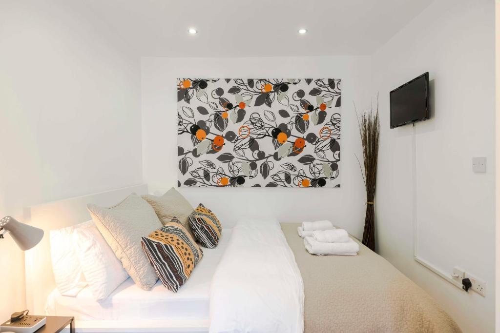 a bedroom with a bed with a picture on the wall at Camden Town Duplex in London