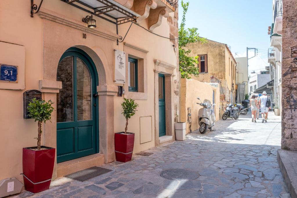 a building with a green door and two potted trees on a street at Boutique Hotel Fortino in Chania