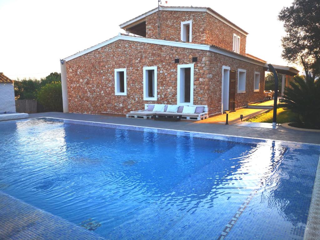 una piscina frente a una casa de ladrillo en Casa rural isleña en Sant Francesc Xavier