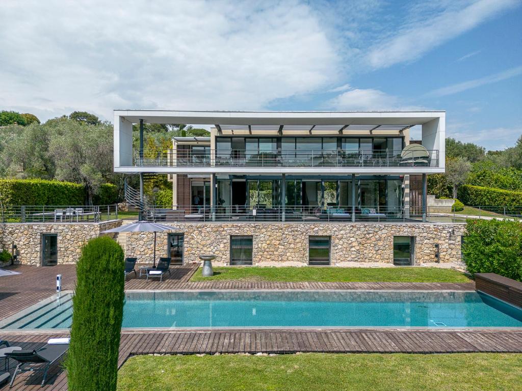 une maison avec une piscine en face de celle-ci dans l'établissement Villa Calypso, à Mouans-Sartoux