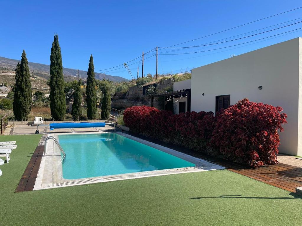 a swimming pool in a yard next to a house at Casa rural con vistas maravillosas en Arico in Sabina Alta