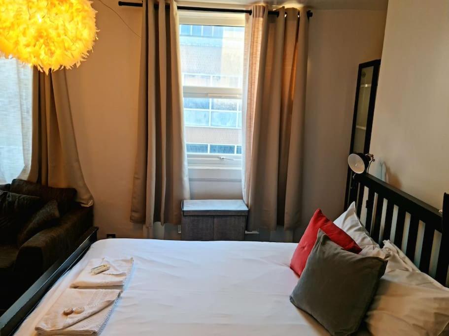 Un dormitorio con una cama blanca con almohadas y una ventana en Lovely One bedroom Aprt in central London en Londres