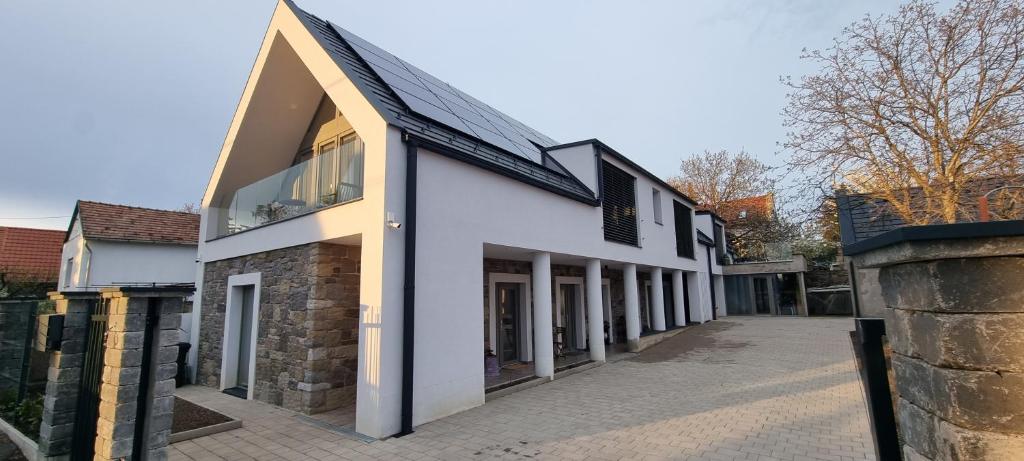 a white house with a black roof at Vánkoska Apartman Tihany in Tihany