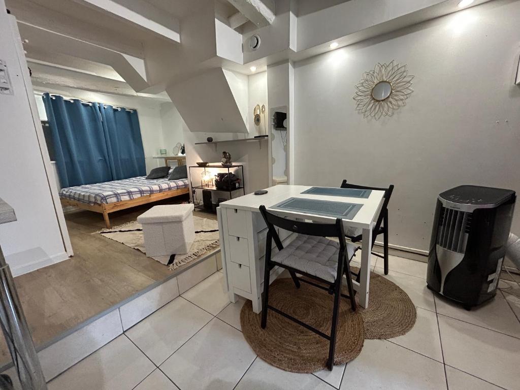 een keuken en een woonkamer met een tafel en stoelen bij La Garde Studio centre historique, proche plage, climatisation, fibre in La Garde