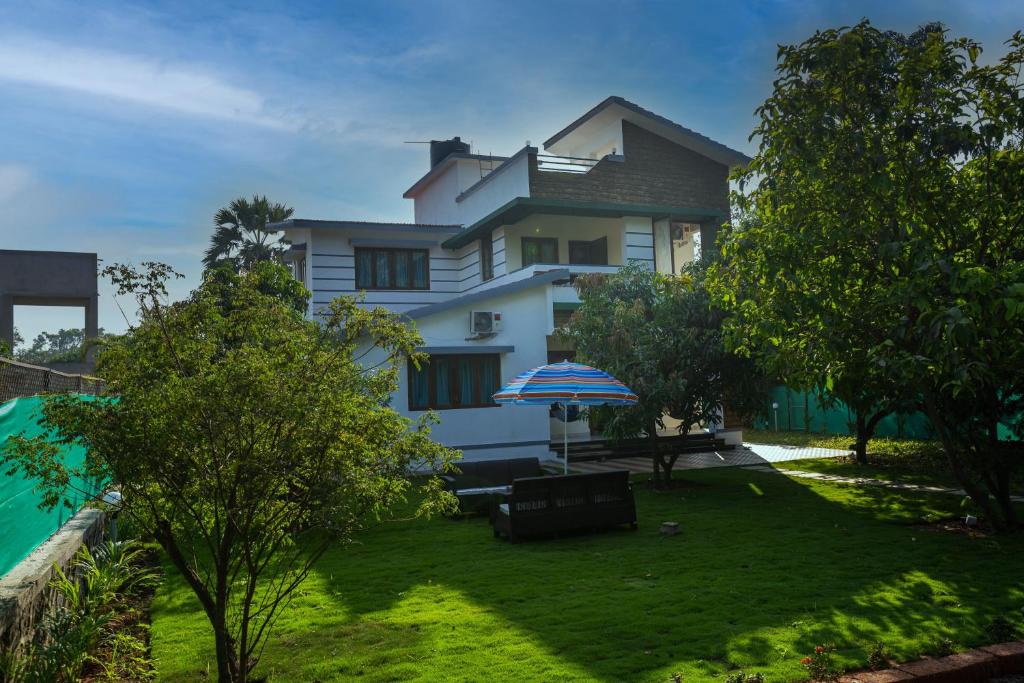 una casa bianca con un ombrello e un cortile di West Valley Villa Casa Vista a Avas