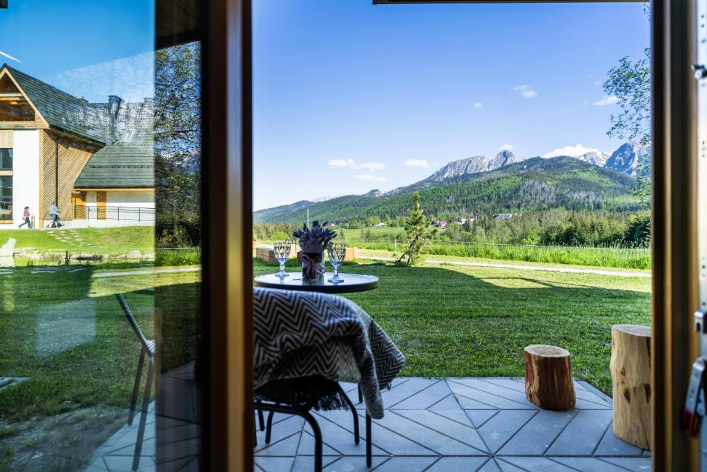 a sliding glass door showing a patio with a table at Apartament Górska Polana by Apart Concept Podhale in Kościelisko