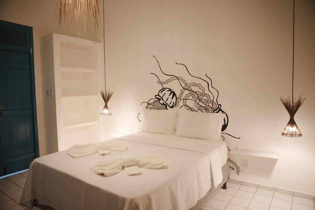 a bedroom with a bed with two towels on it at 4 quartos ao lado da praia do Patacho in Pôrto de Pedras