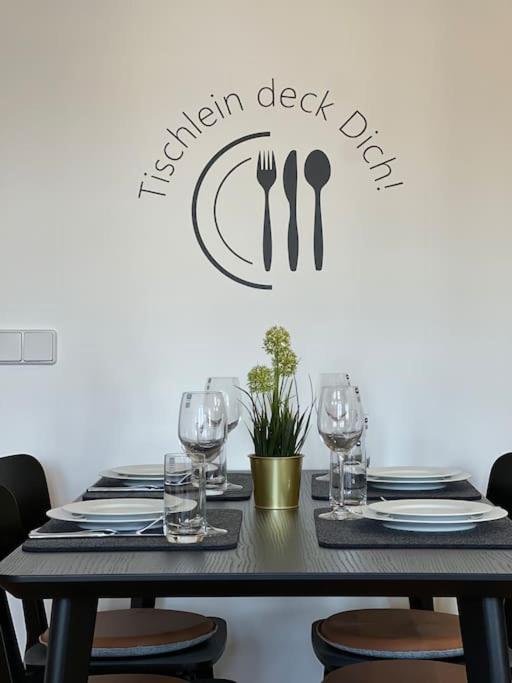 a black table with glasses and a sign that reads garden desk dip at Goethe Palais Suite Zauberlehrling 4P l Lift l Parkplatz I Zentrum I Helios in Aue