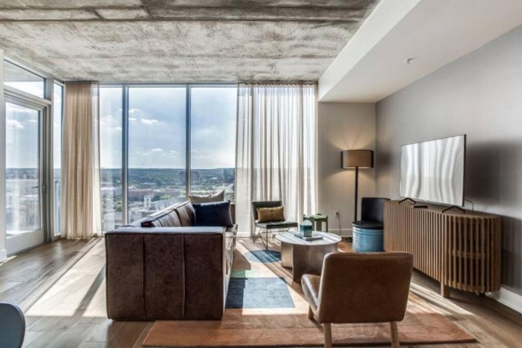 a living room with a couch and chairs and windows at 2 BR Lux Panoramic View - Rainey in Austin