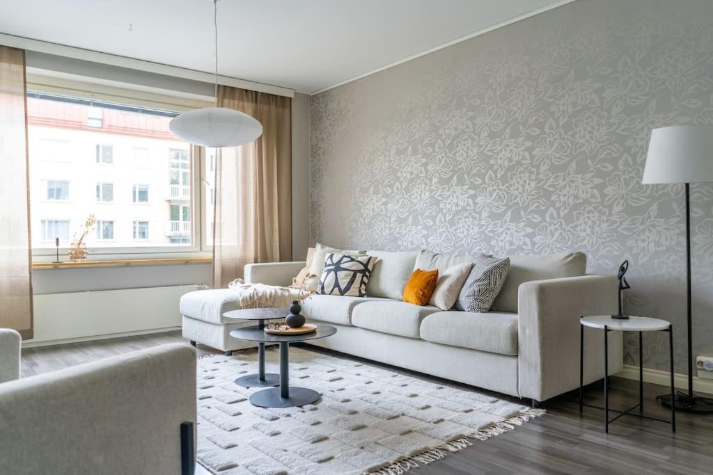 sala de estar con sofá blanco y mesa en Spacious 2br Apartment in the City Center, en Tampere