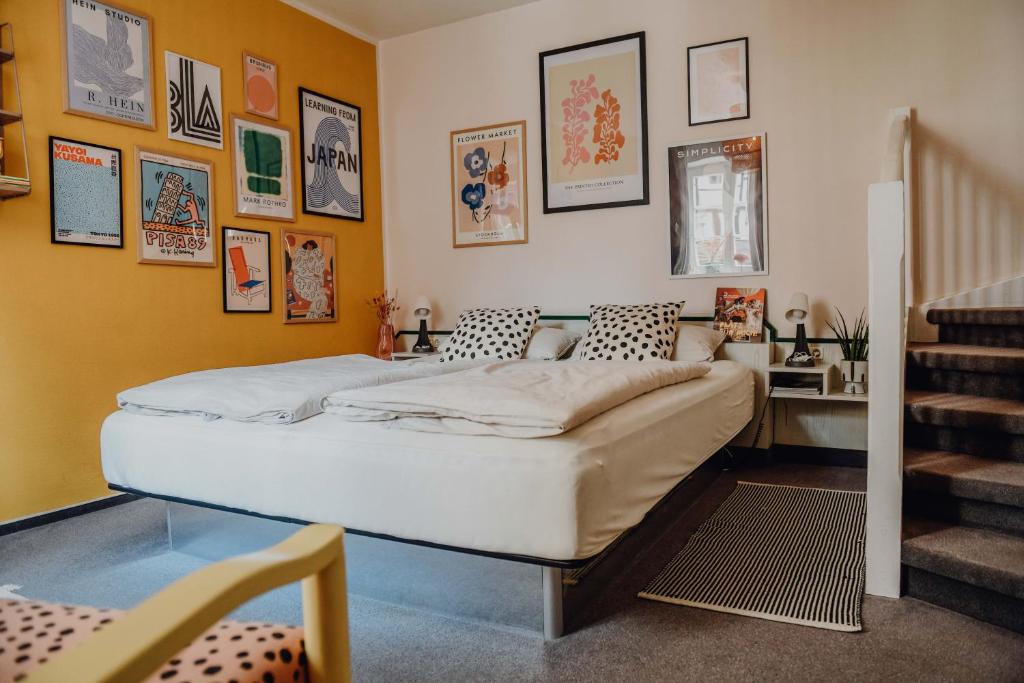 ein Schlafzimmer mit einem Bett und einige Bilder an der Wand in der Unterkunft sleepArt room for 2 in Celle