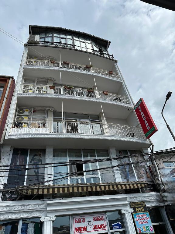 a tall white building with balconies on it at Avangard in Batumi