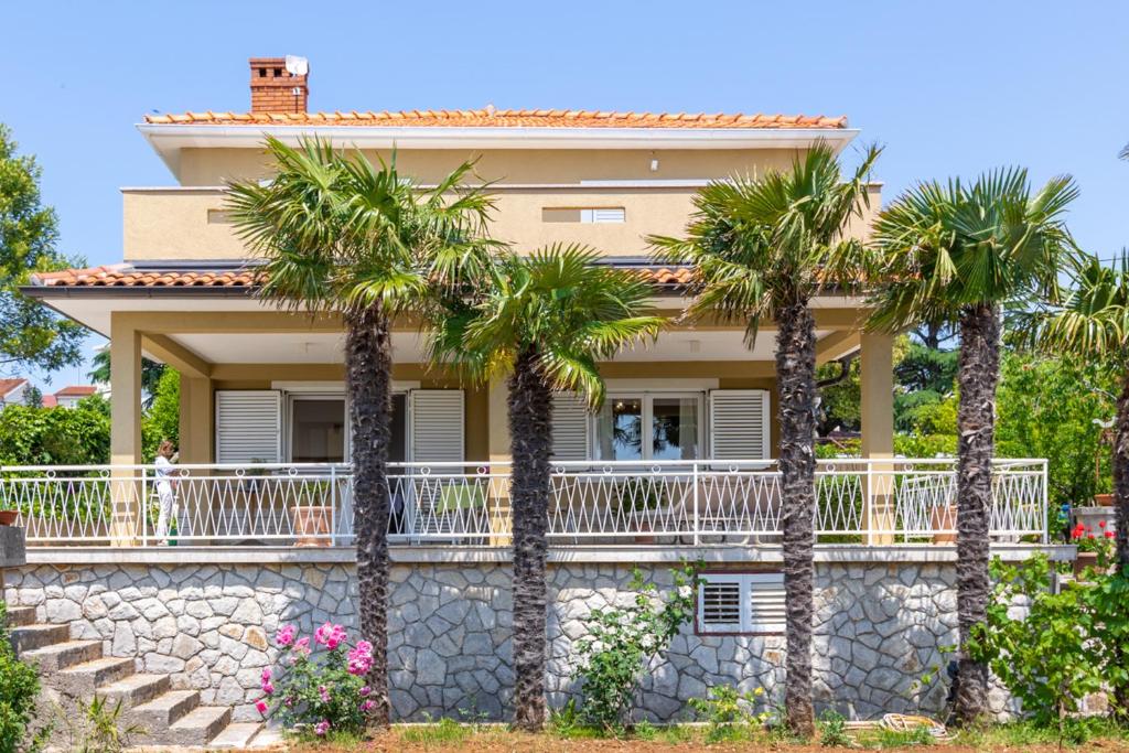 a house with palm trees in front of it at Villa Marica, Premium residence, Krk in Krk
