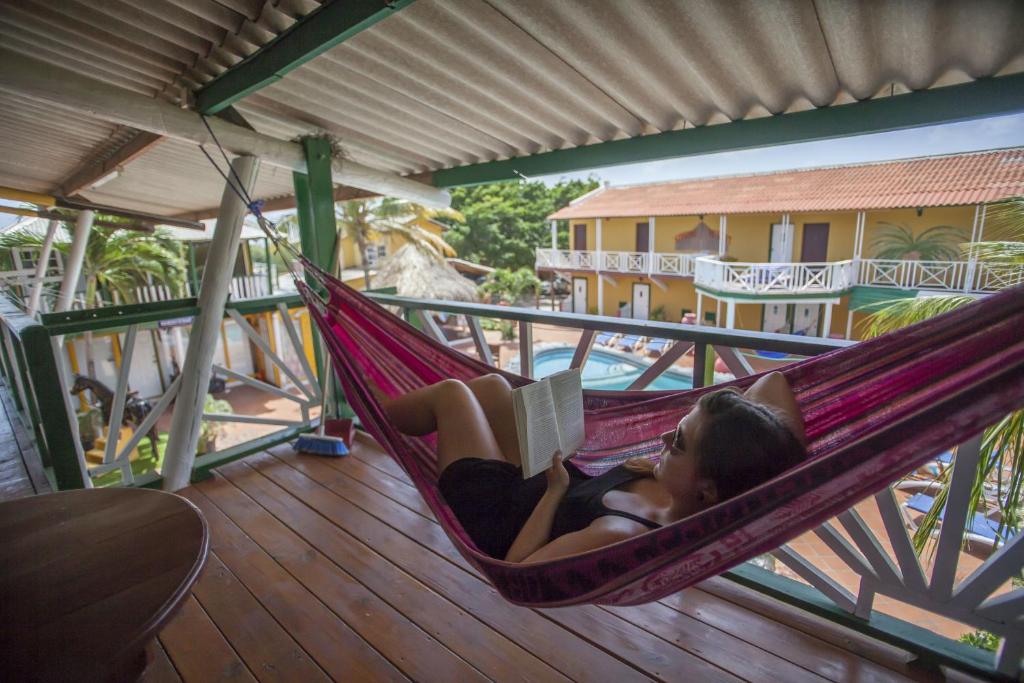 una mujer acostada en una hamaca leyendo un libro en Rancho el Sobrino, en Sabana Westpunt