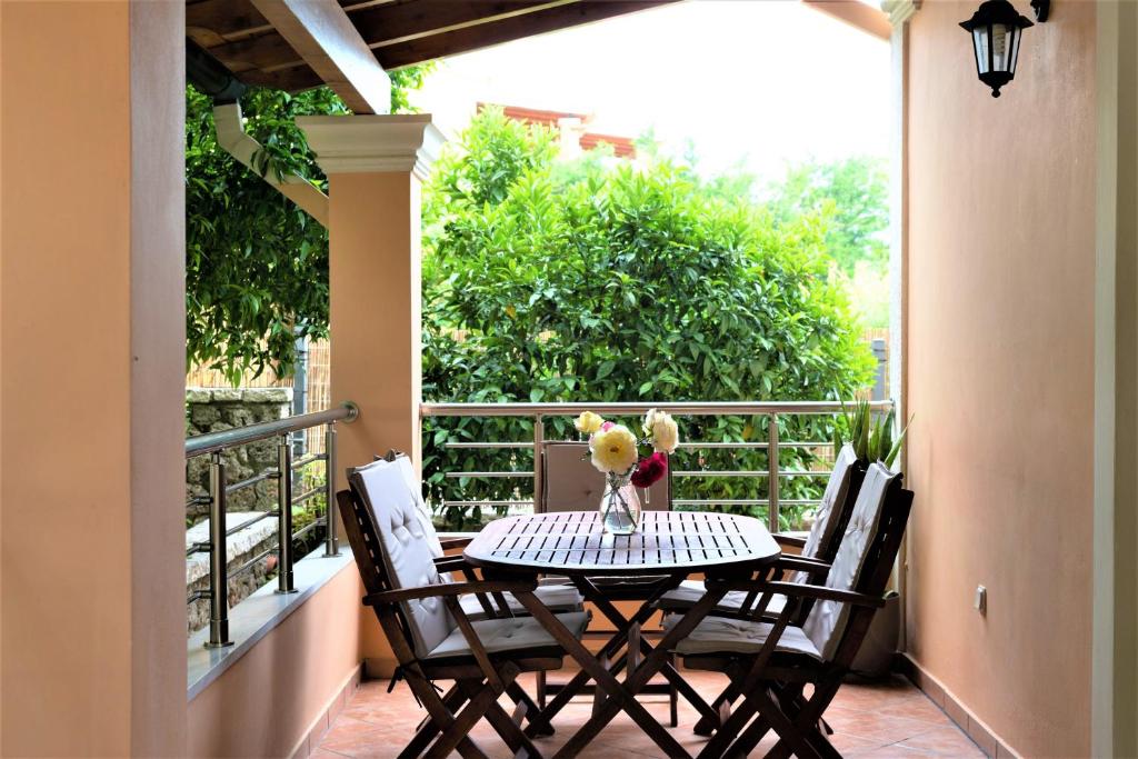 einen Tisch und Stühle auf einem Balkon mit einem Tisch in der Unterkunft La Bella Vita - Luxury Holiday House close to Corfu Town in Potamós
