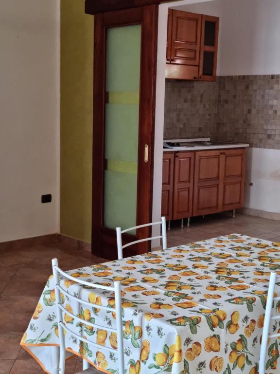 a kitchen with a table and two chairs and a kitchen with a table at Casa vacanza Amanda in Nicotera Marina