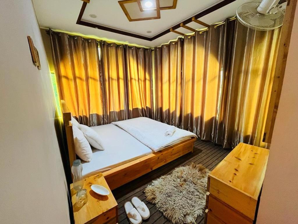 Habitación pequeña con cama y ventana en HIKK Inn en Skardu