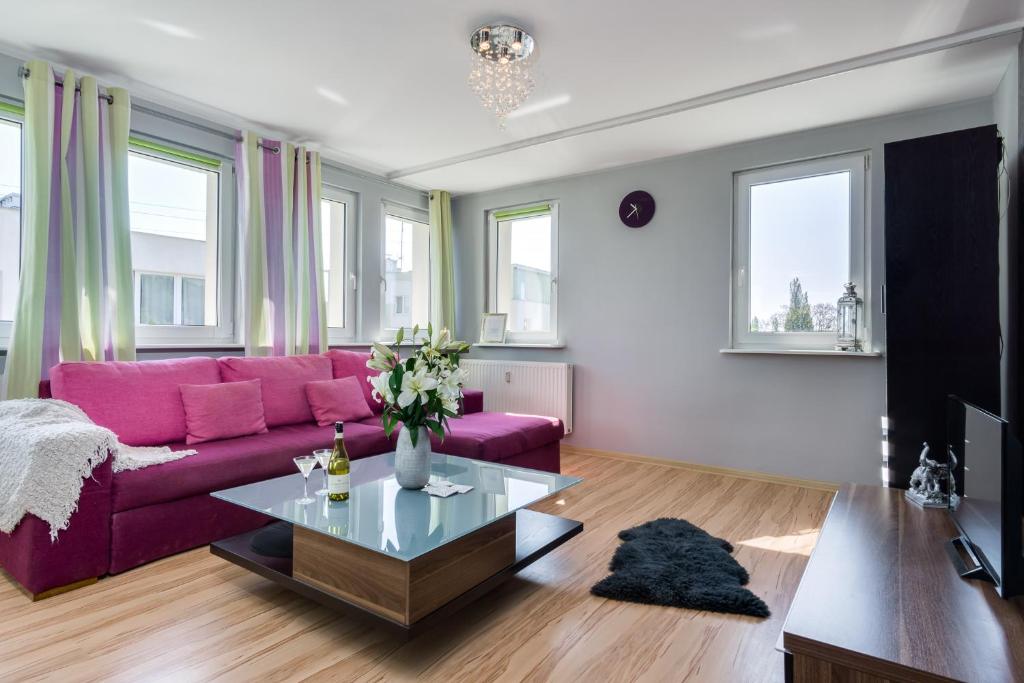 sala de estar con sofá púrpura y mesa en Elite Apartments Sopot Center en Sopot