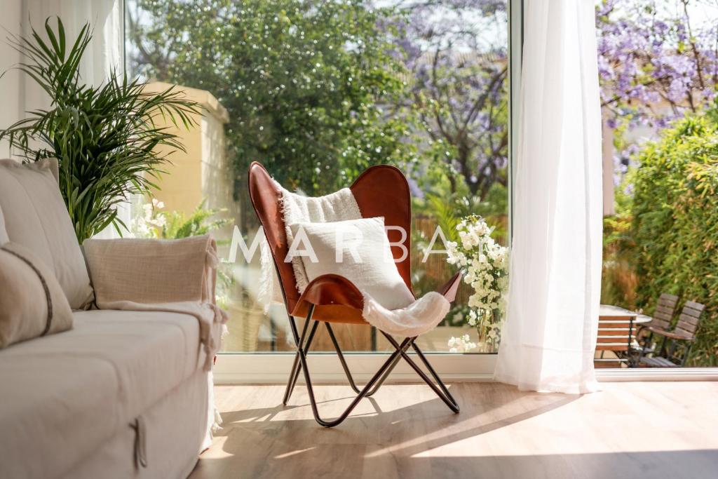 une chaise assise dans un salon à côté d'une fenêtre dans l'établissement Ca Bambú, à Jávea