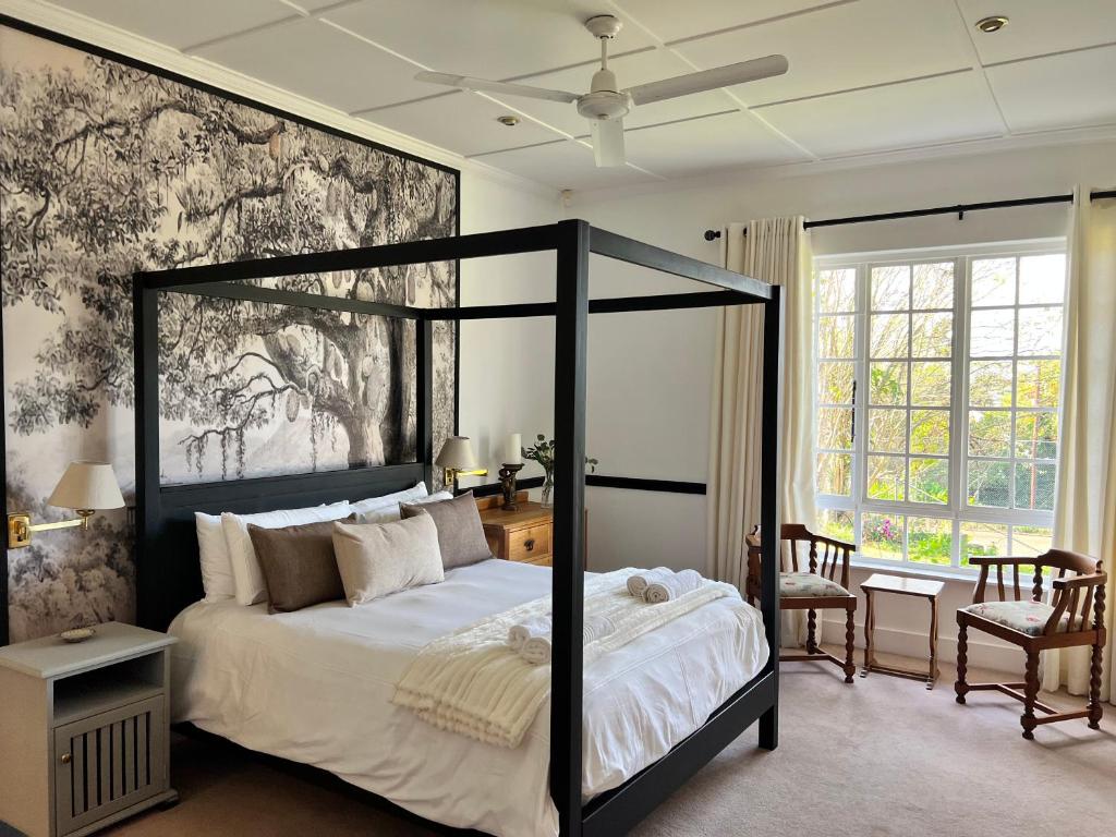 um quarto com uma cama grande com uma moldura preta em Edgehill em Pietermaritzburg
