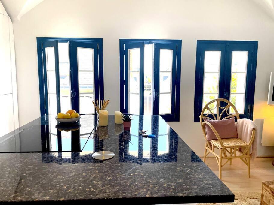 un salon avec une table en verre et des chaises dans l'établissement Charmant Duplex à 1min La Baule, au Pouliguen