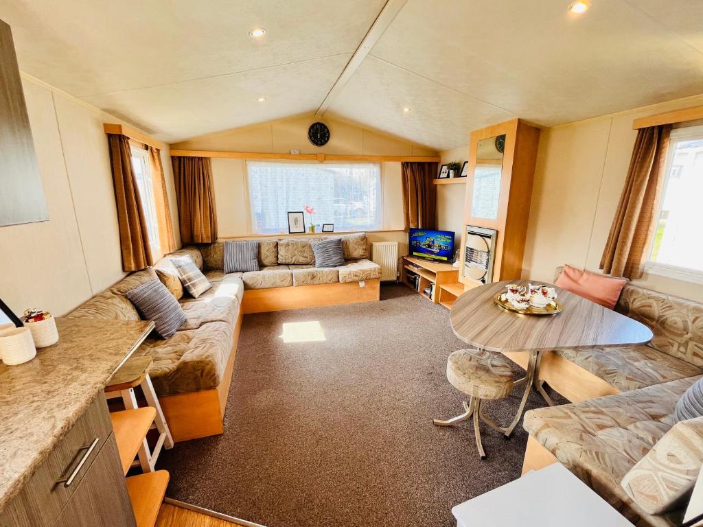 een woonkamer met een bank en een tafel bij Lola’s Caravan. Your home away from home. in Parkeston