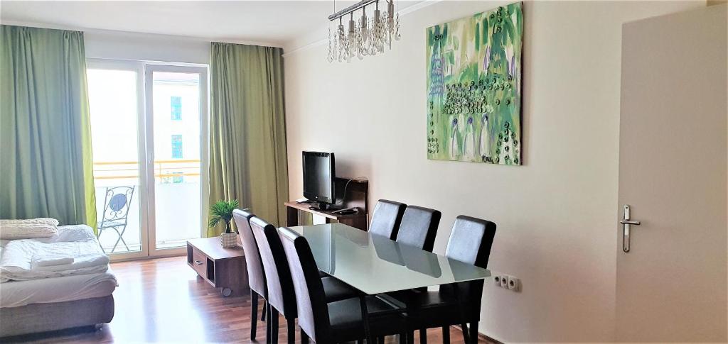 a living room with a dining room table and chairs at govienna - Messe Wien Apartment in Vienna