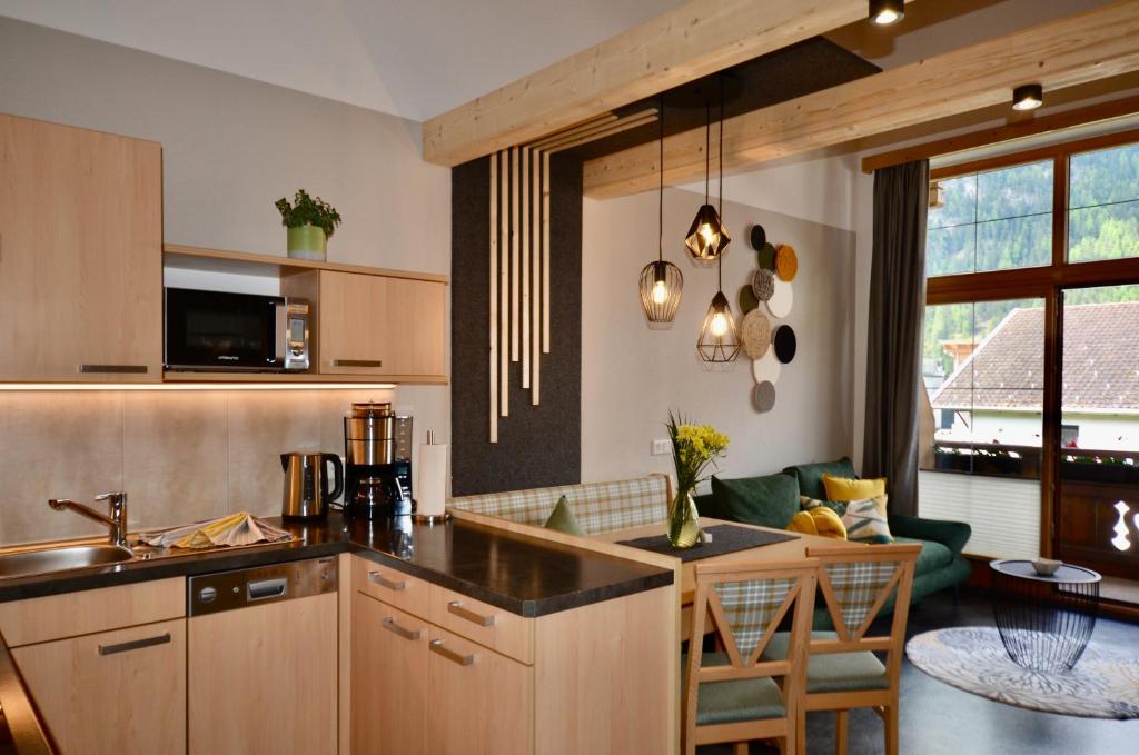 a kitchen with a counter top and a living room at Apart Marie-Therese in Umhausen