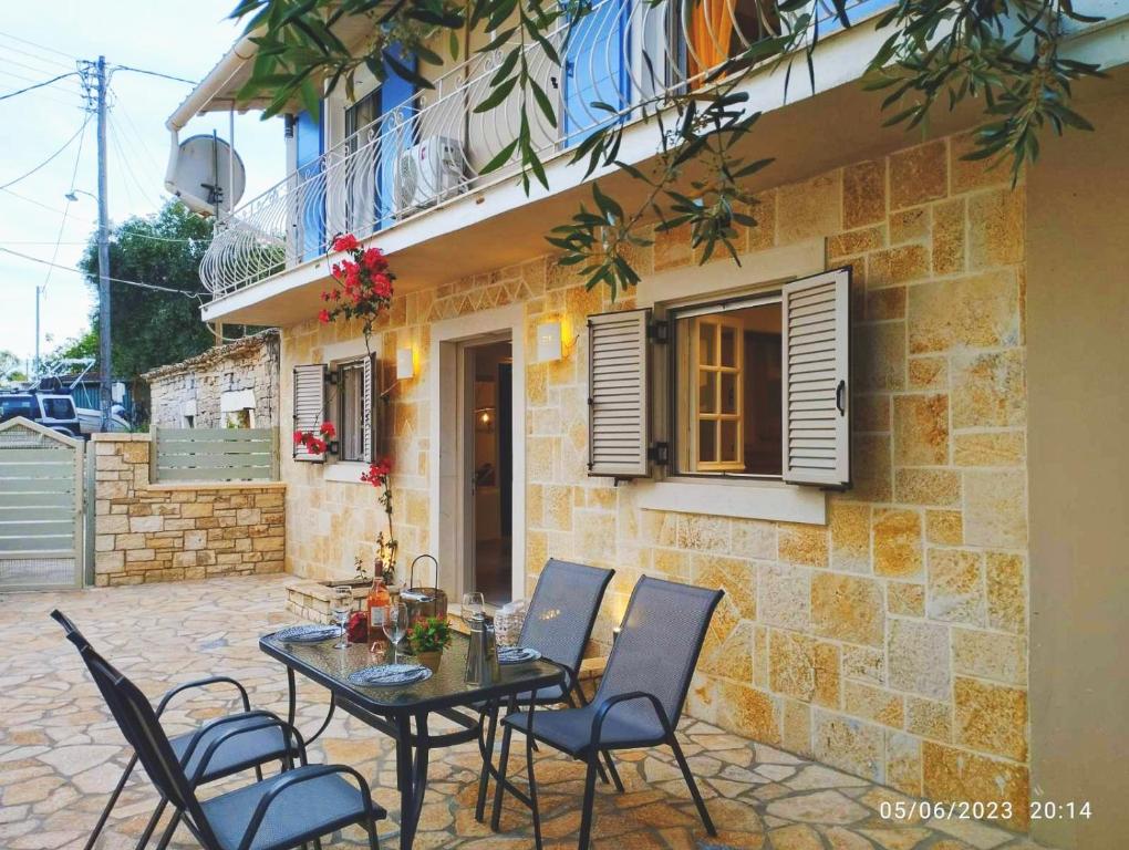 a patio with a table and chairs in front of a building at Spiro's cottage by Alegria apartments in Vlachopoulátika