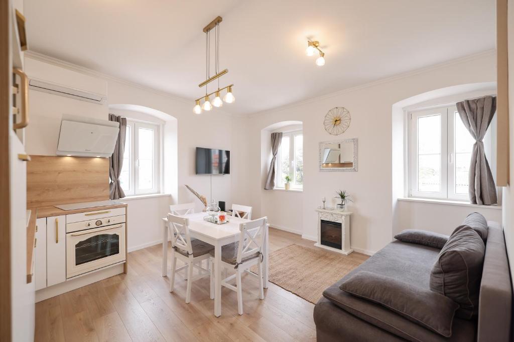 een keuken en woonkamer met een tafel en een bank bij Sea Gate Apartment in Zadar
