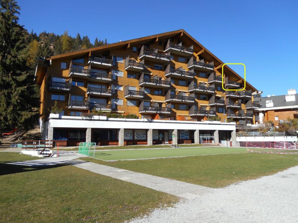 un gran edificio con una pista de tenis enfrente en Apartment in Anzère, en Anzère