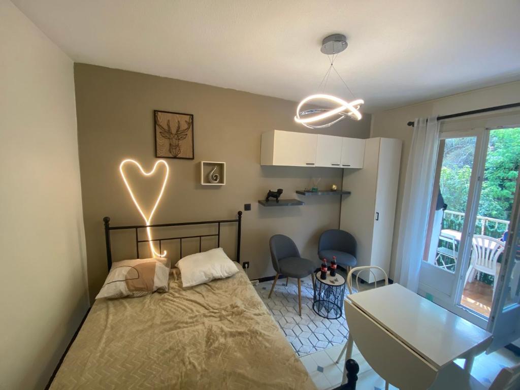 - une chambre avec un lit doté d'une lumière du cœur sur le mur dans l'établissement Joli T1 Amélie-les-Bains-Palalda, à Amélie-les-Bains-Palalda