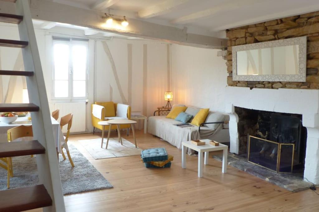 ein Wohnzimmer mit einem Sofa und einem Kamin in der Unterkunft Exceptionnel Appartement à Vannes, vue sur les remparts in Vannes