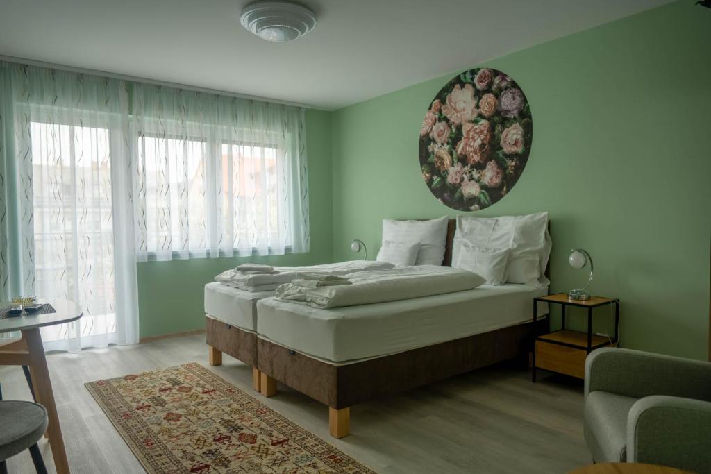 a bedroom with a bed in a green room at Anton Apartmanház in Balatonfüred