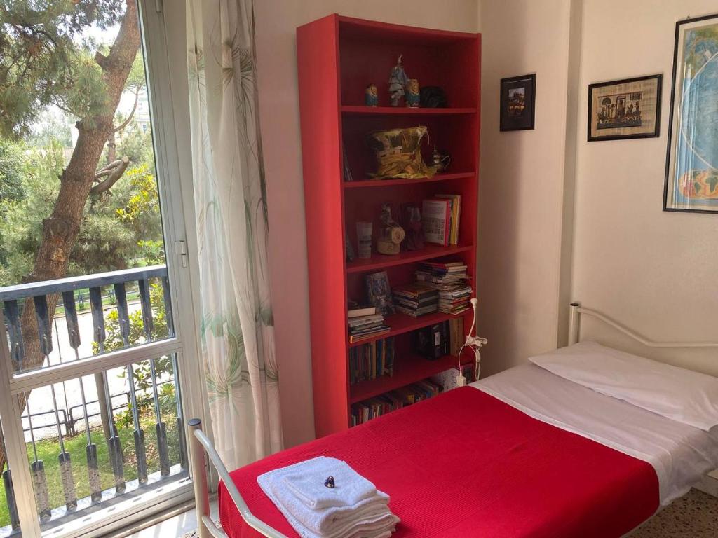 1 dormitorio con estantería roja junto a la cama en Oasi Verde en Nápoles