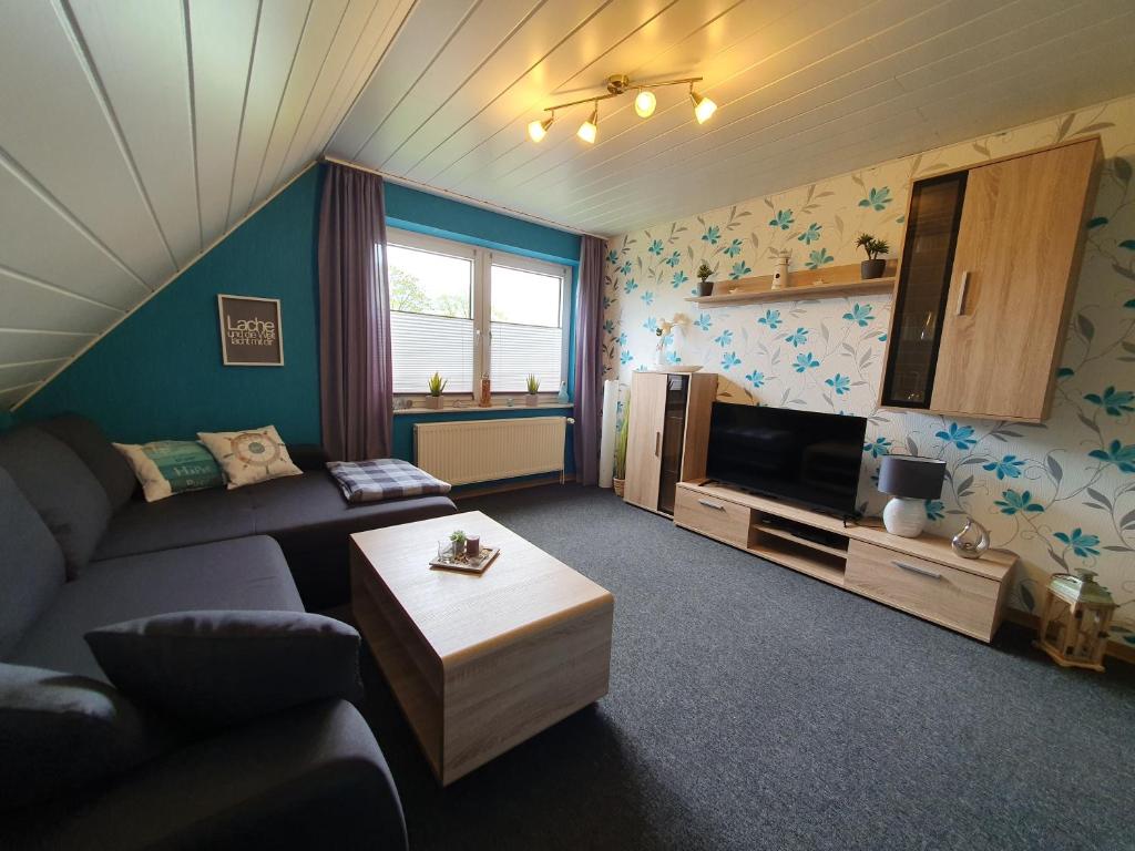 ein Wohnzimmer mit einem Sofa und einem TV in der Unterkunft Ferienwohnung im Fehnland 35667 in Uplengen